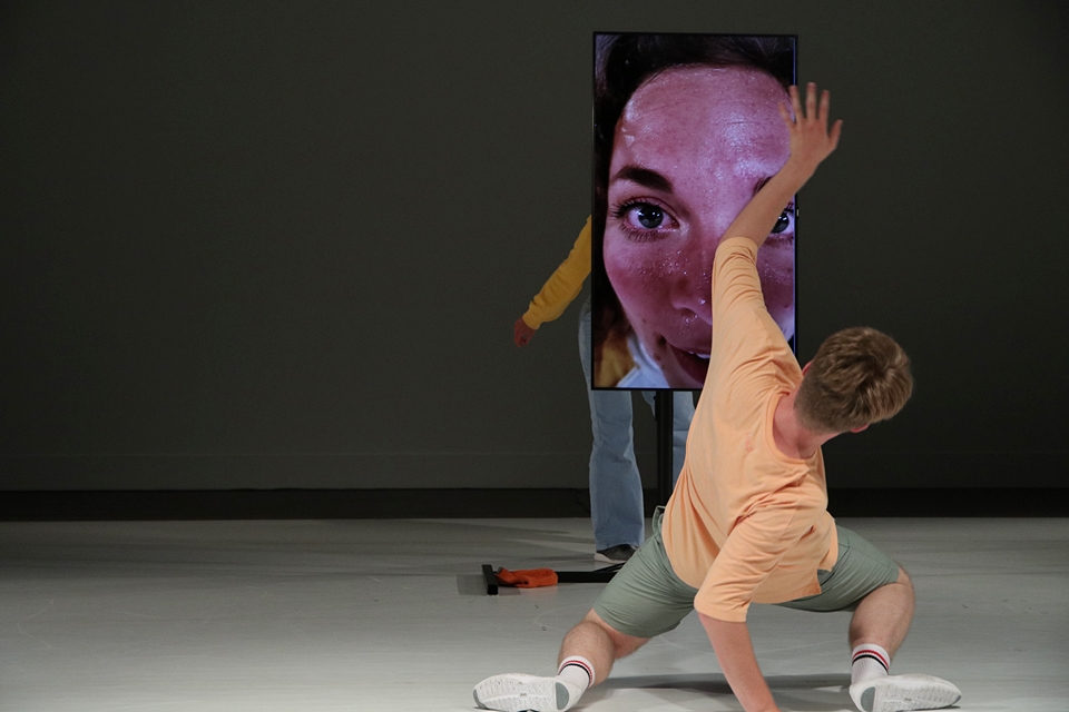 Mann tanzt vor Bildschirm mit Gesicht einer Frau
